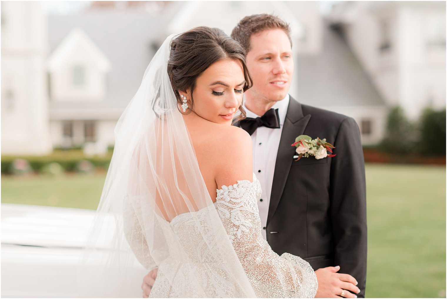 bride looks over shoulder during NJ wedding portraits outside Park Chateau Estate