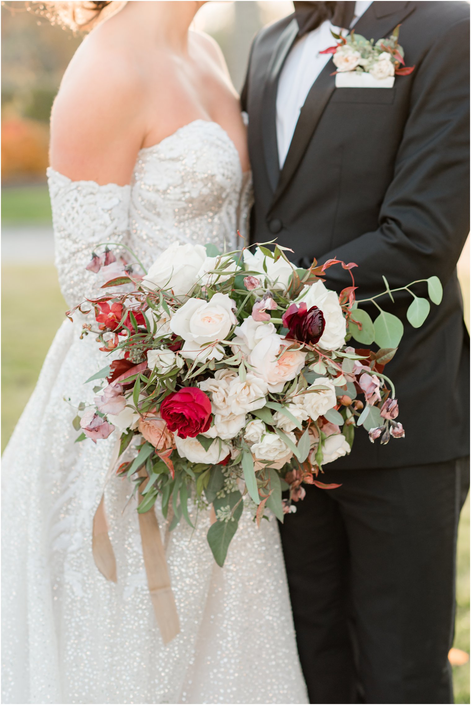 bride and groom hug with bride's bouquet beside them with ivory flowers 