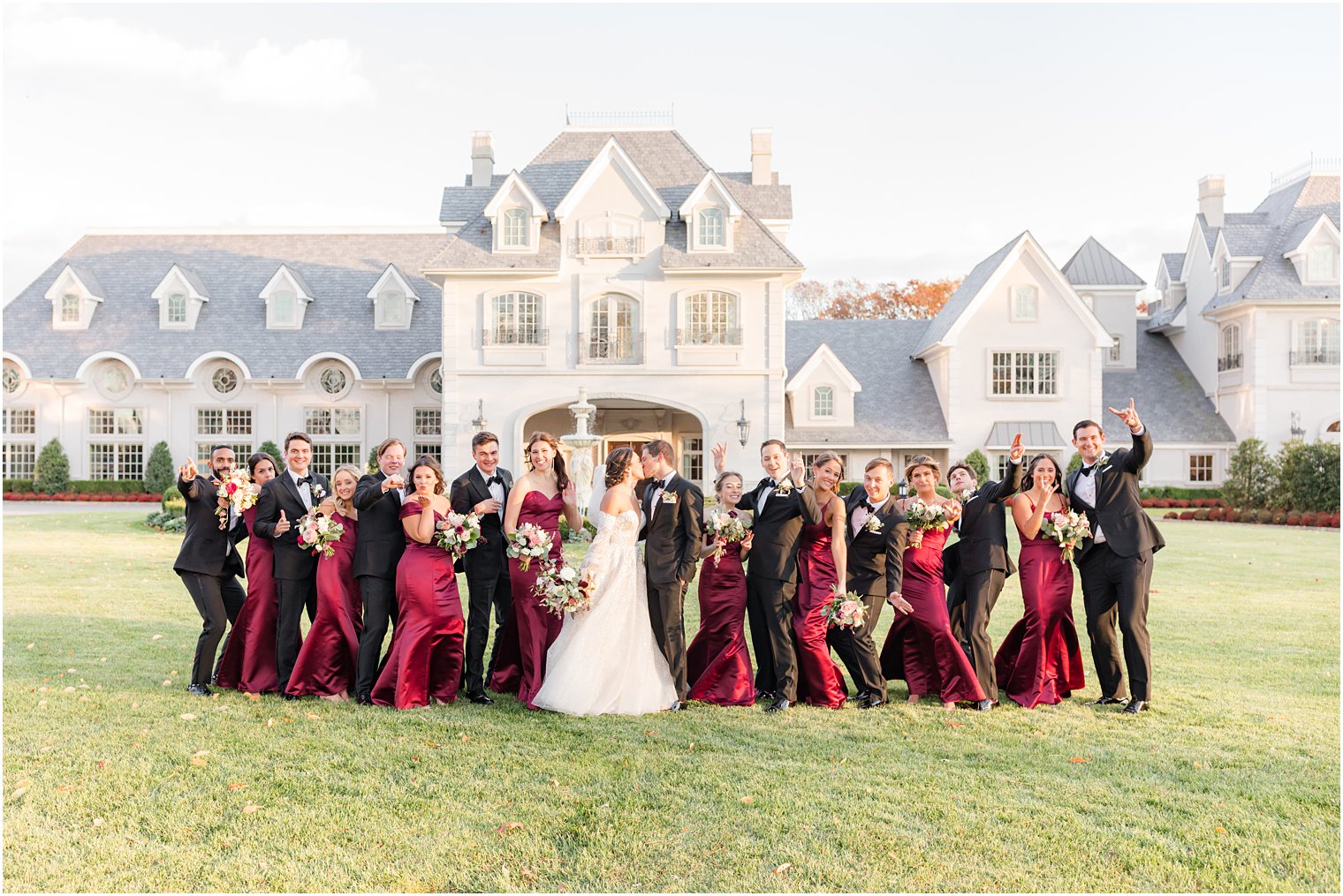 bride and groom kiss while wedding party cheers outside Park Chateau Estate