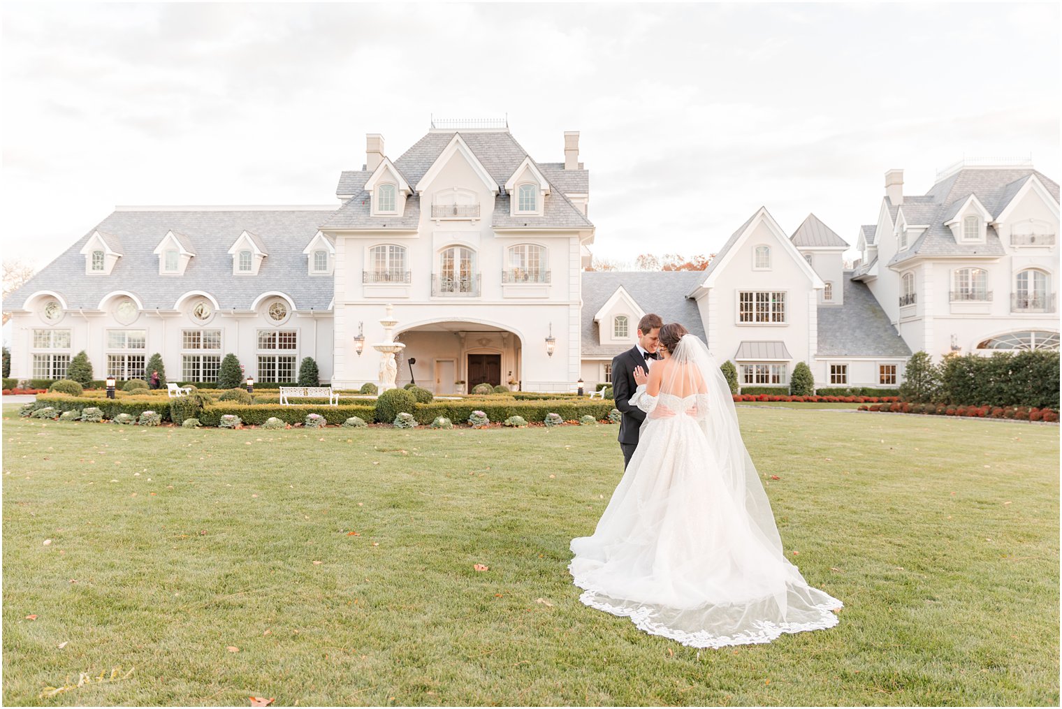 bride and groom hug on lawn outside Park Chateau Estate