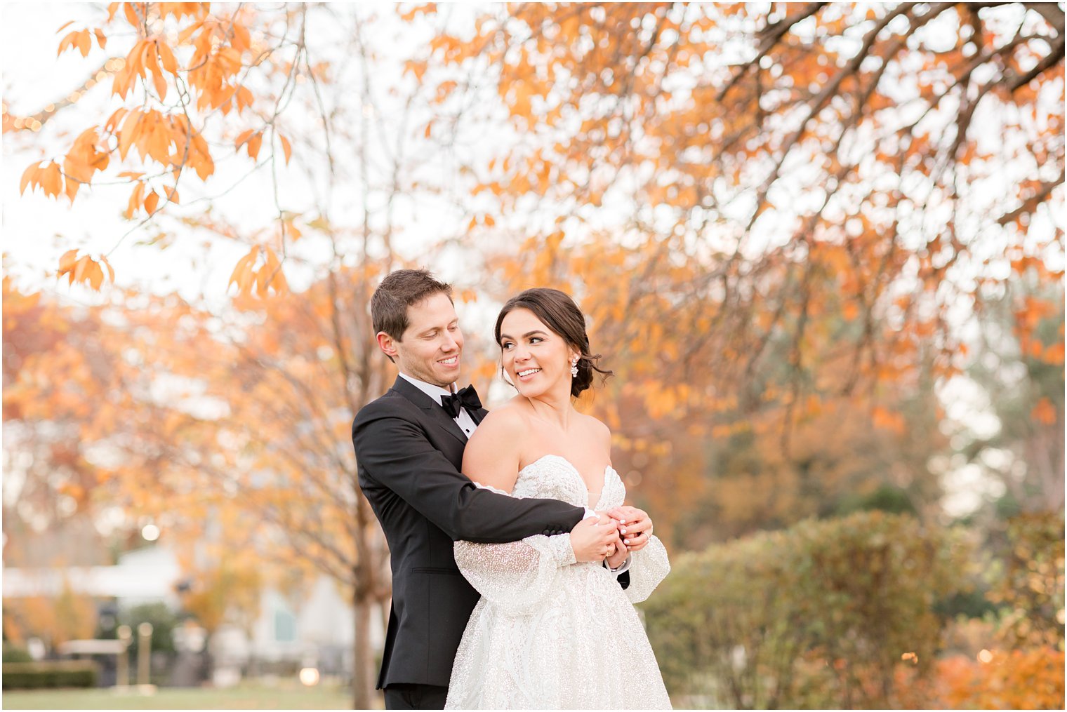 groom hugs bride from behind during NJ wedding portraits at Park Chateau Estate