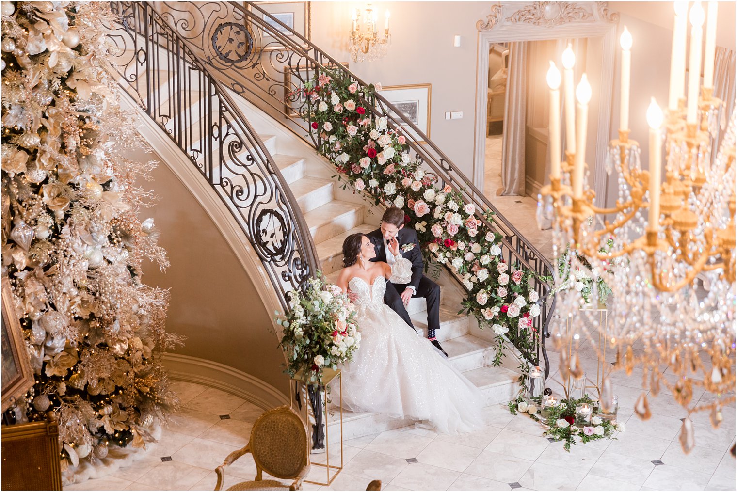 bride and groom sit on grand staircase for holiday wedding at Park Chateau Estate