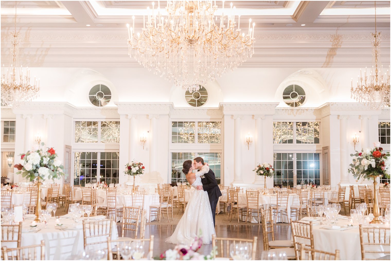 newlyweds kiss in ballroom at Park Chateau Estate with decor for winter wedding