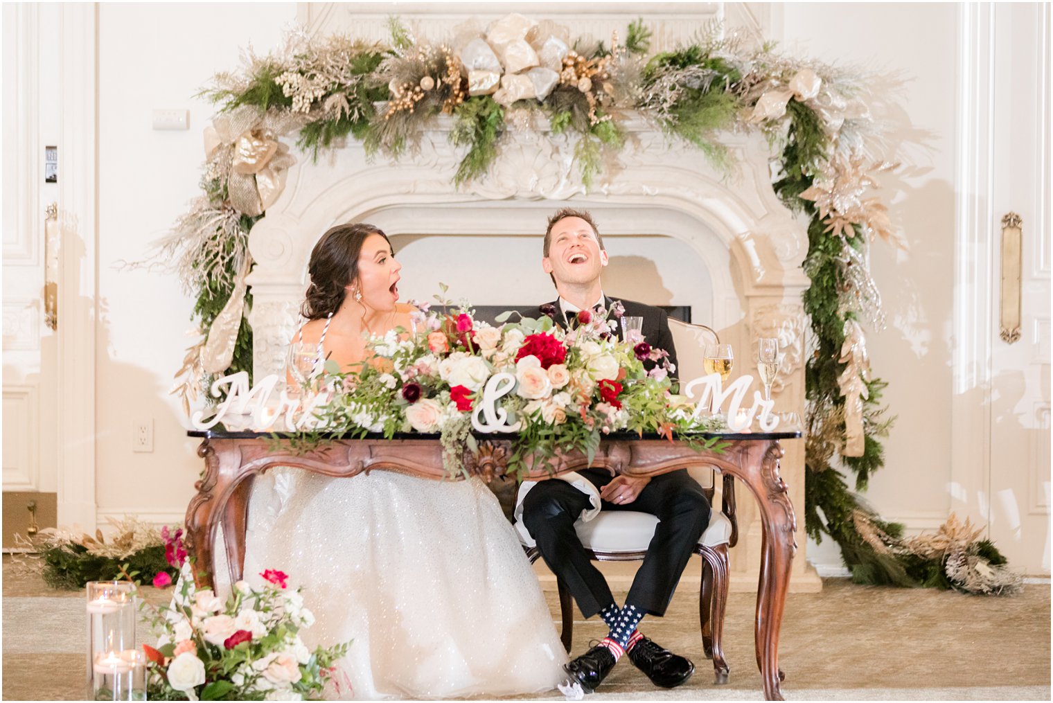 groom laughs sitting at sweetheart table at Park Chateau Estate during toasts 