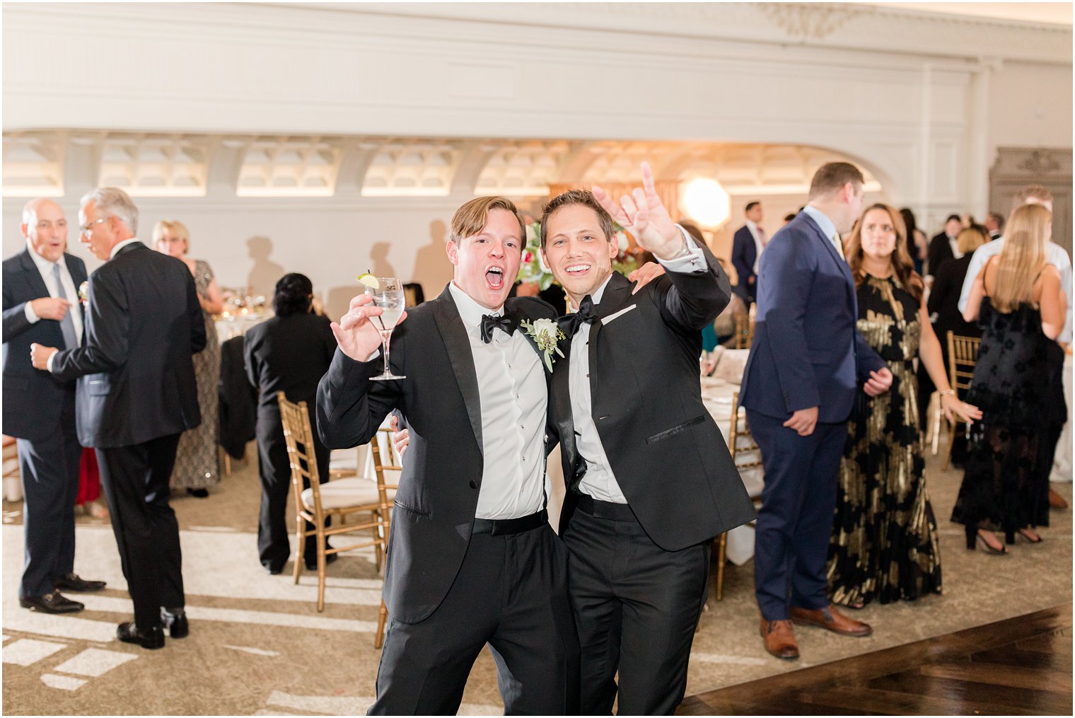 groom and groomsman hug on dance floor