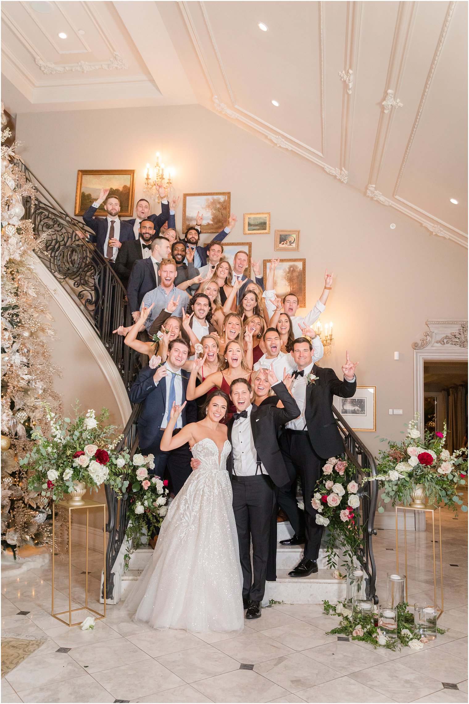 bride and groom stand on steps with college friends at Park Chateau Estate wedding