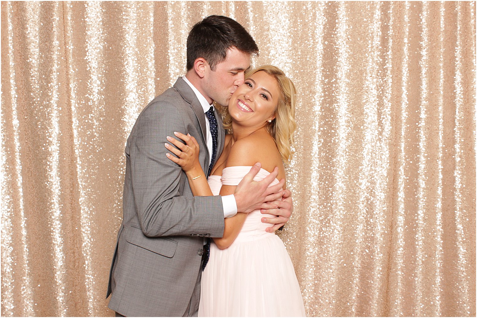 bridesmaid and date kiss in photo booth 