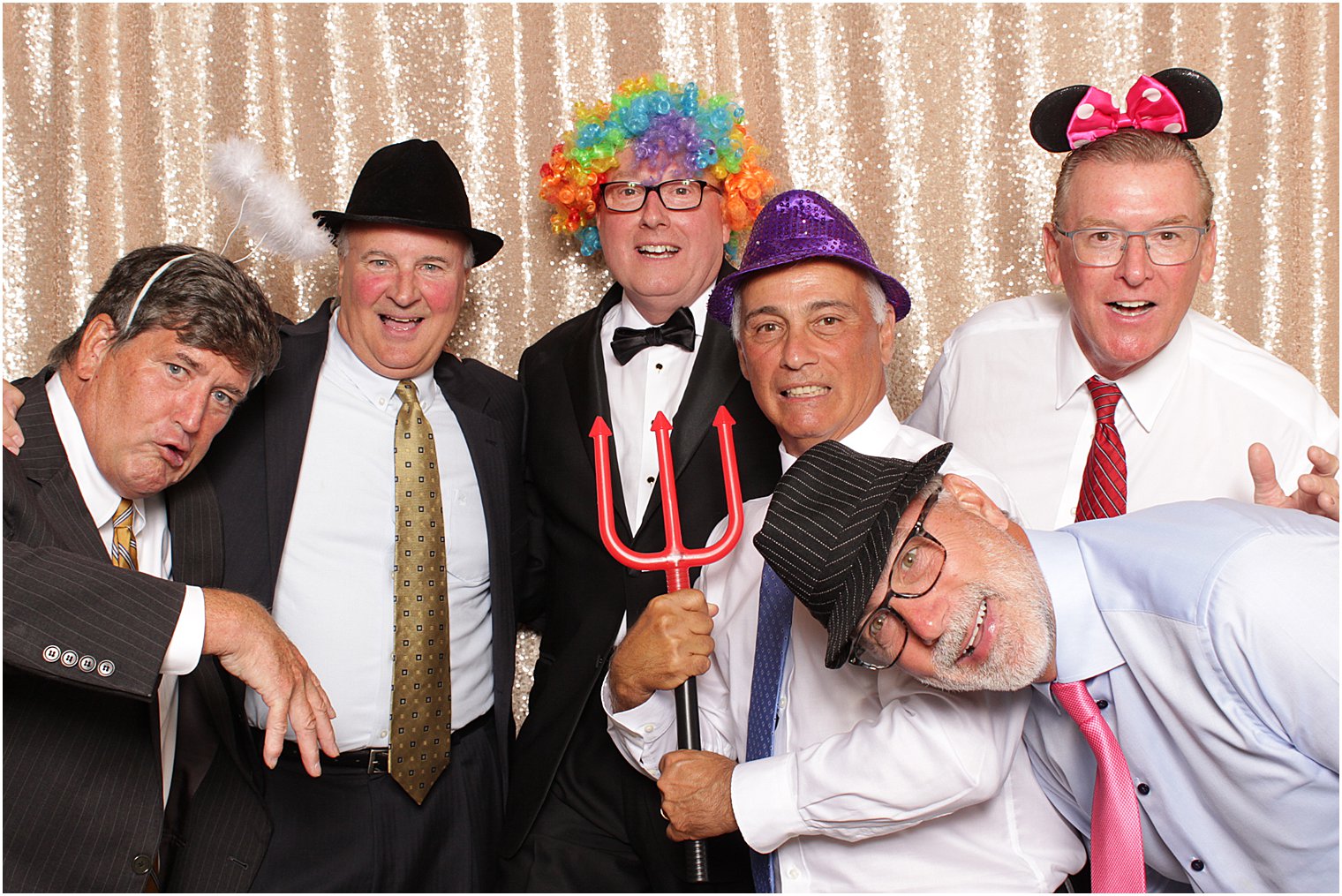 older men pose together with prop hats during Indian Trail Club photo booth