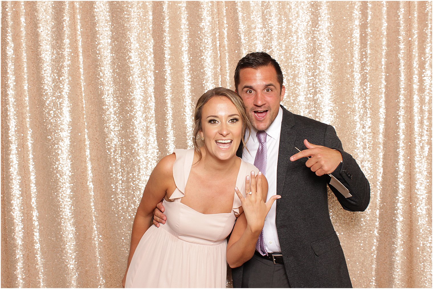 couple points at woman's engagement ring during Indian Trail Club photo booth