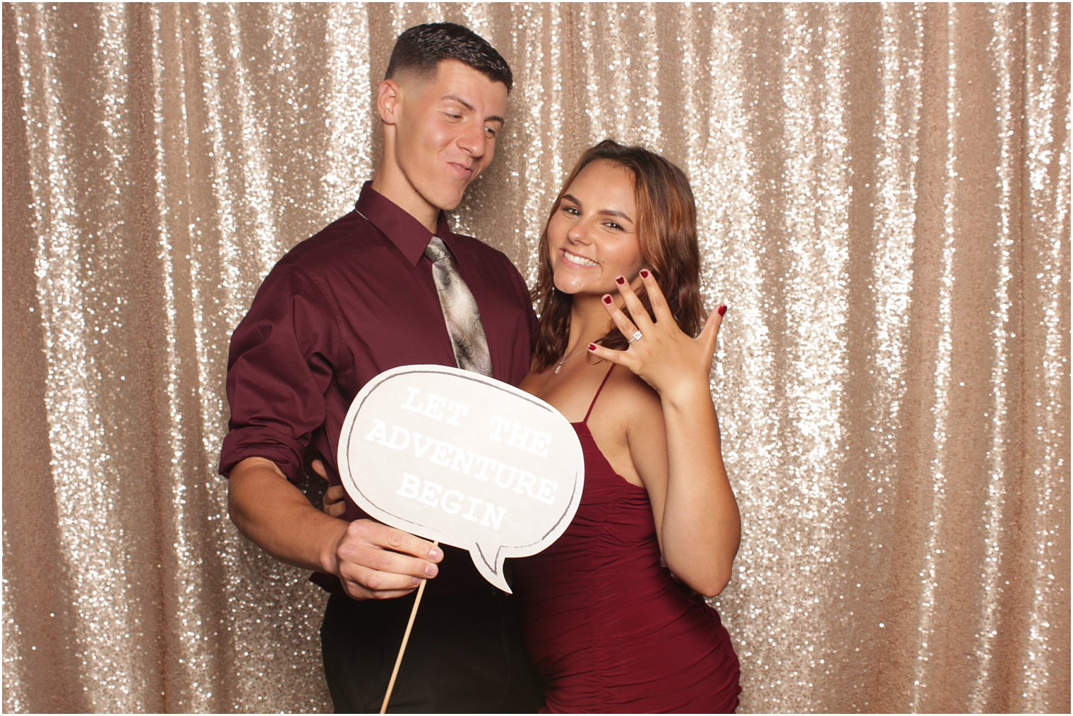 engaged couple shows off woman's ring during photo booth photos 