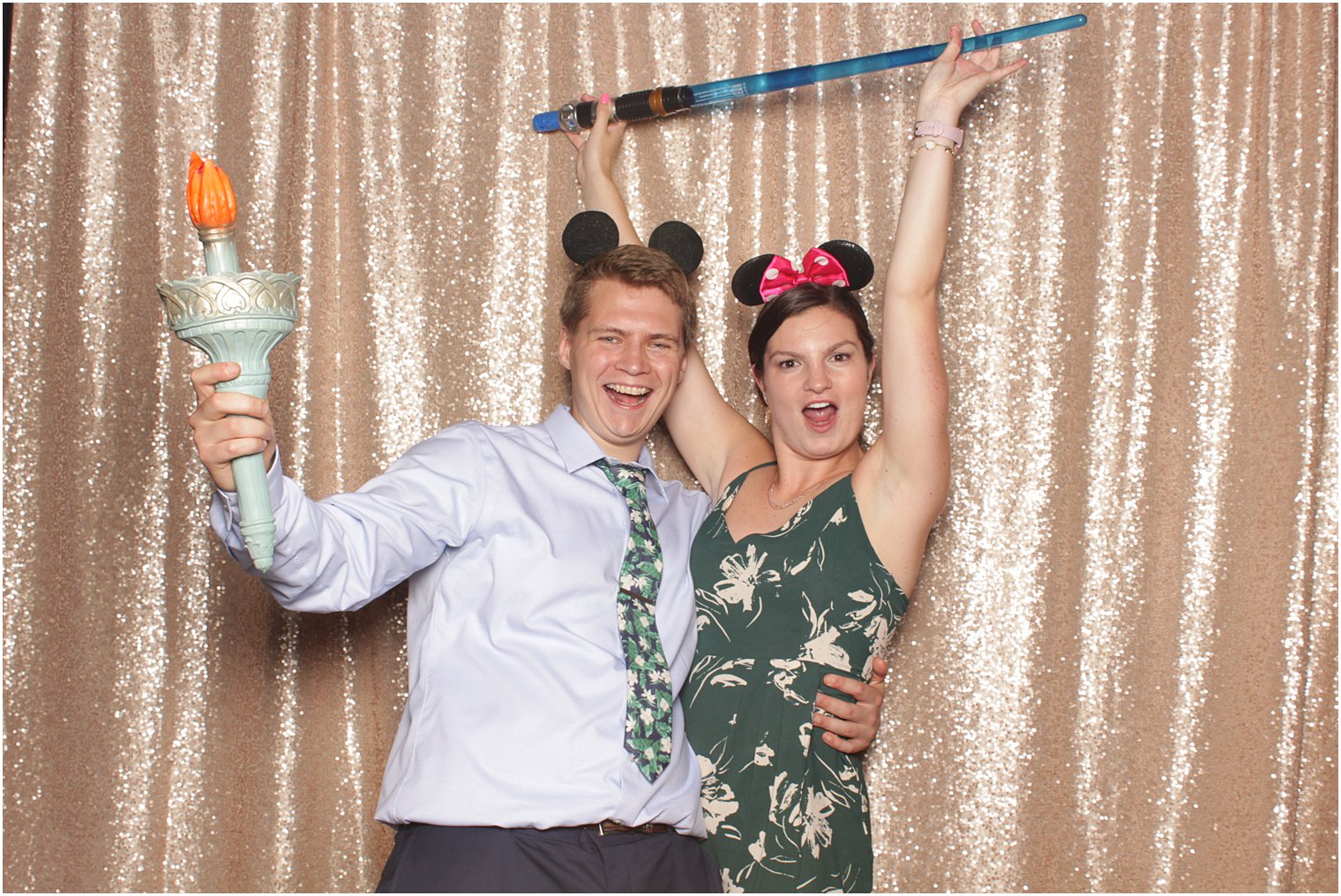 couple poses in mouse ears during photo booth fun