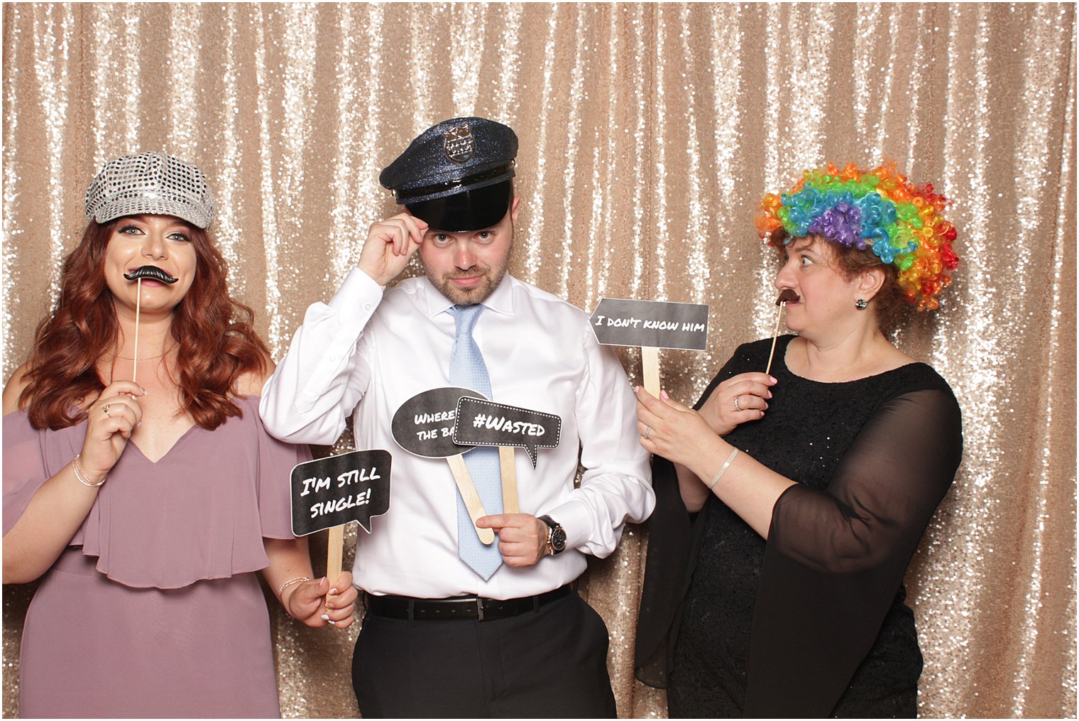 family holds signs up during photo booth at wedding reception