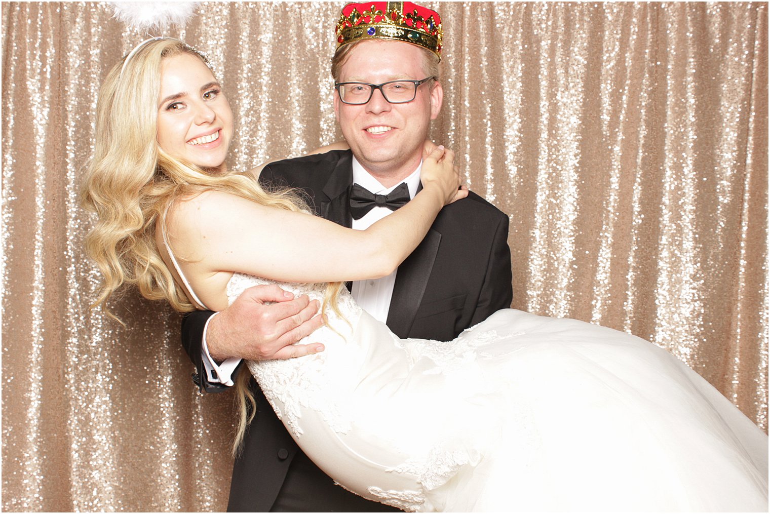 groom holds bride up during The Manor Photo Booth
