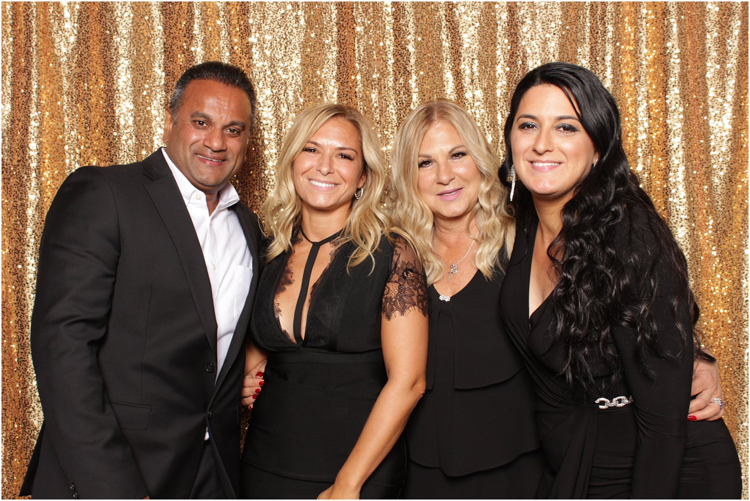 group of four adults pose in photo booth 