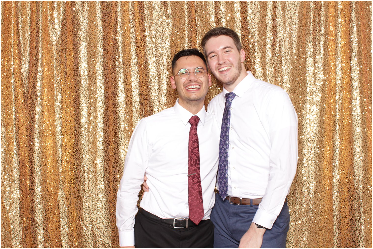 two guys stand together during photo booth 