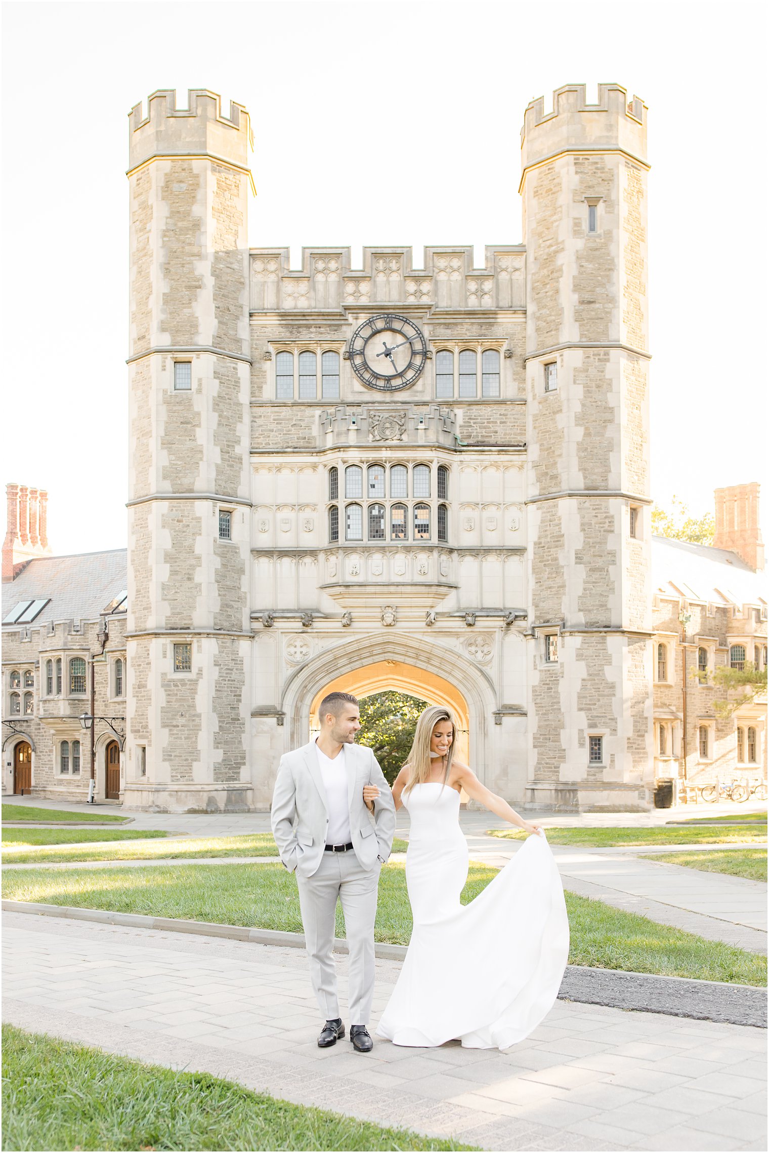 bride holds skirt of white dress out during engagement photos at Princeton University