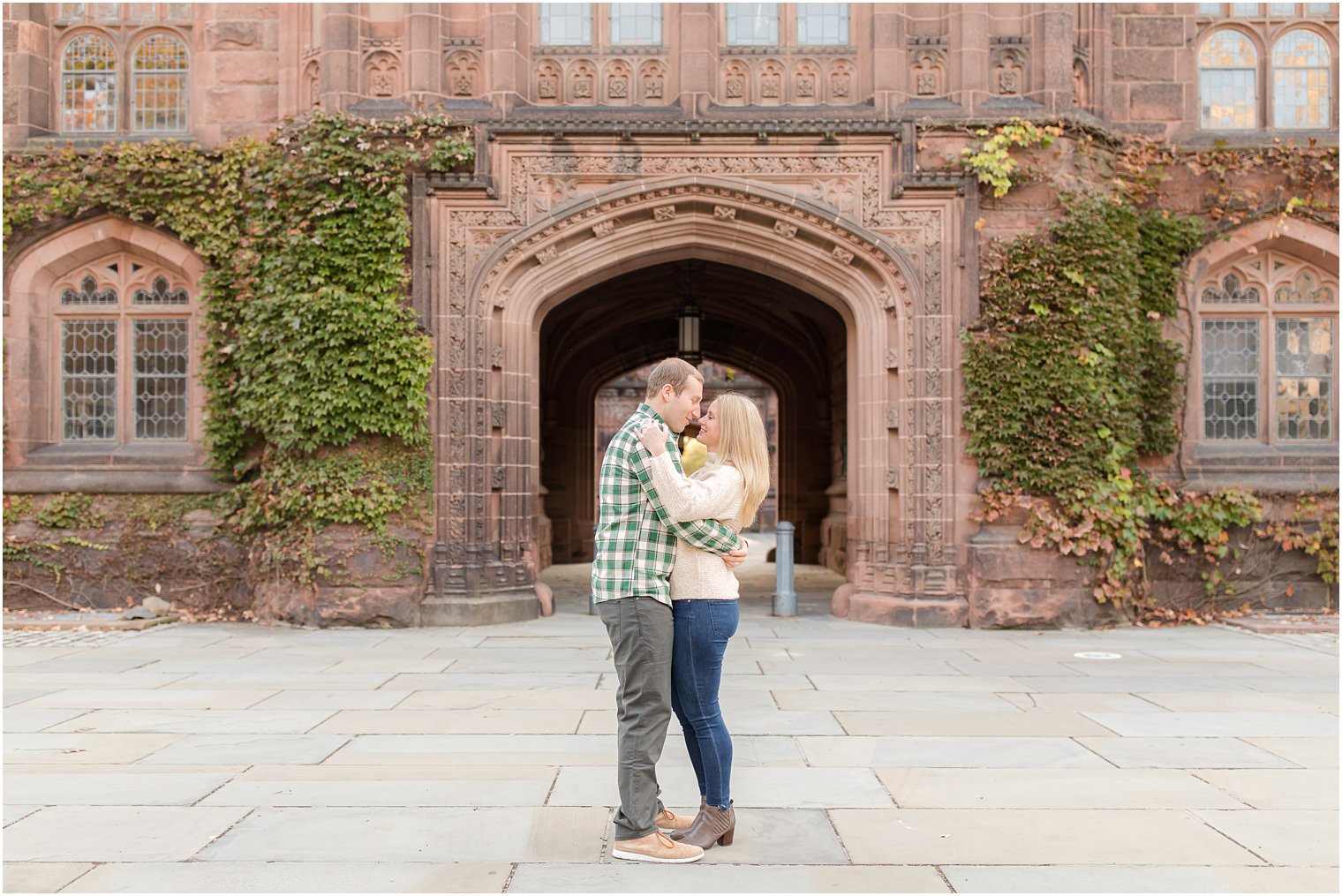 bride and groom pose by historic building at Princeton University 
