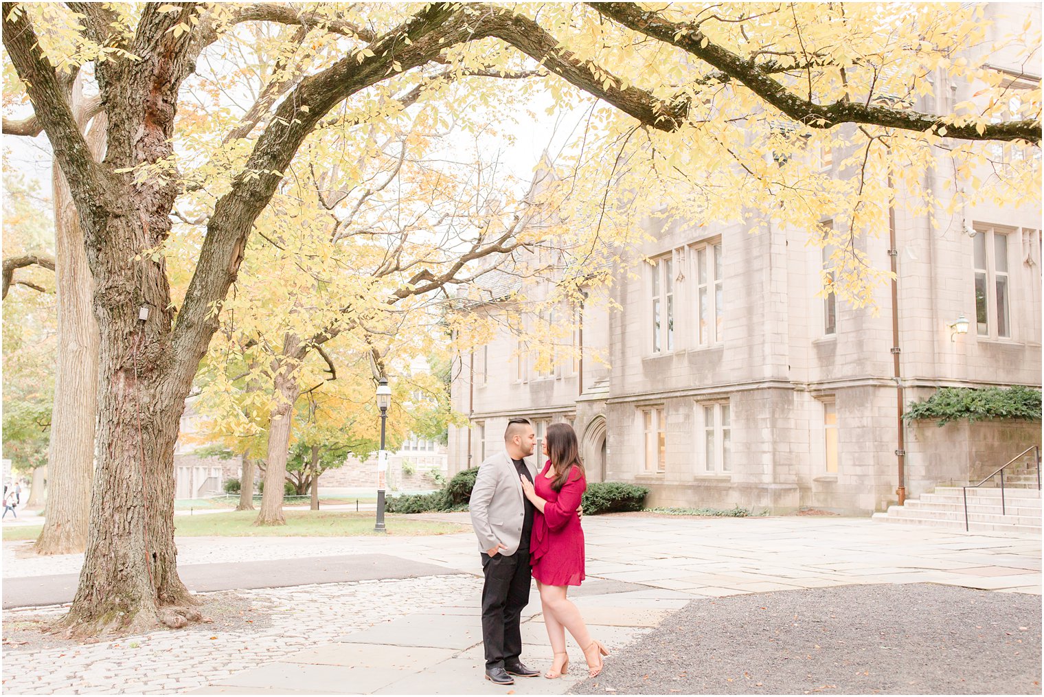 bride and groom pose near chapel during engagement session in Princeton NJ