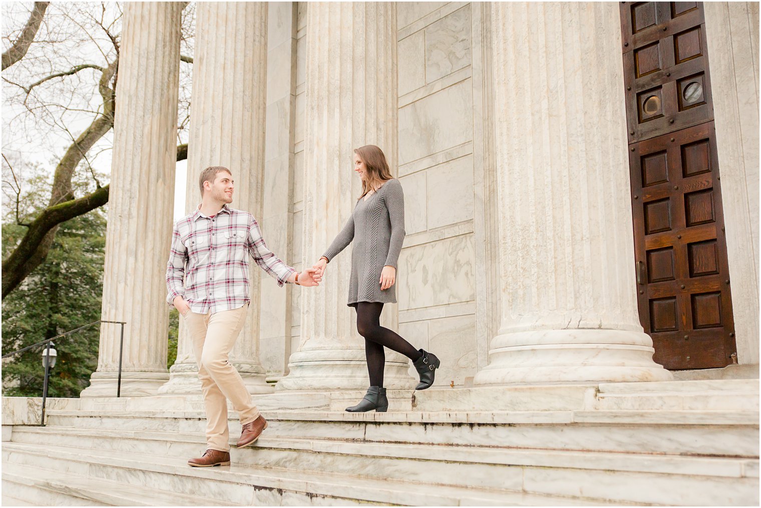 bride and groom walk down steps during engagement photos at Princeton University