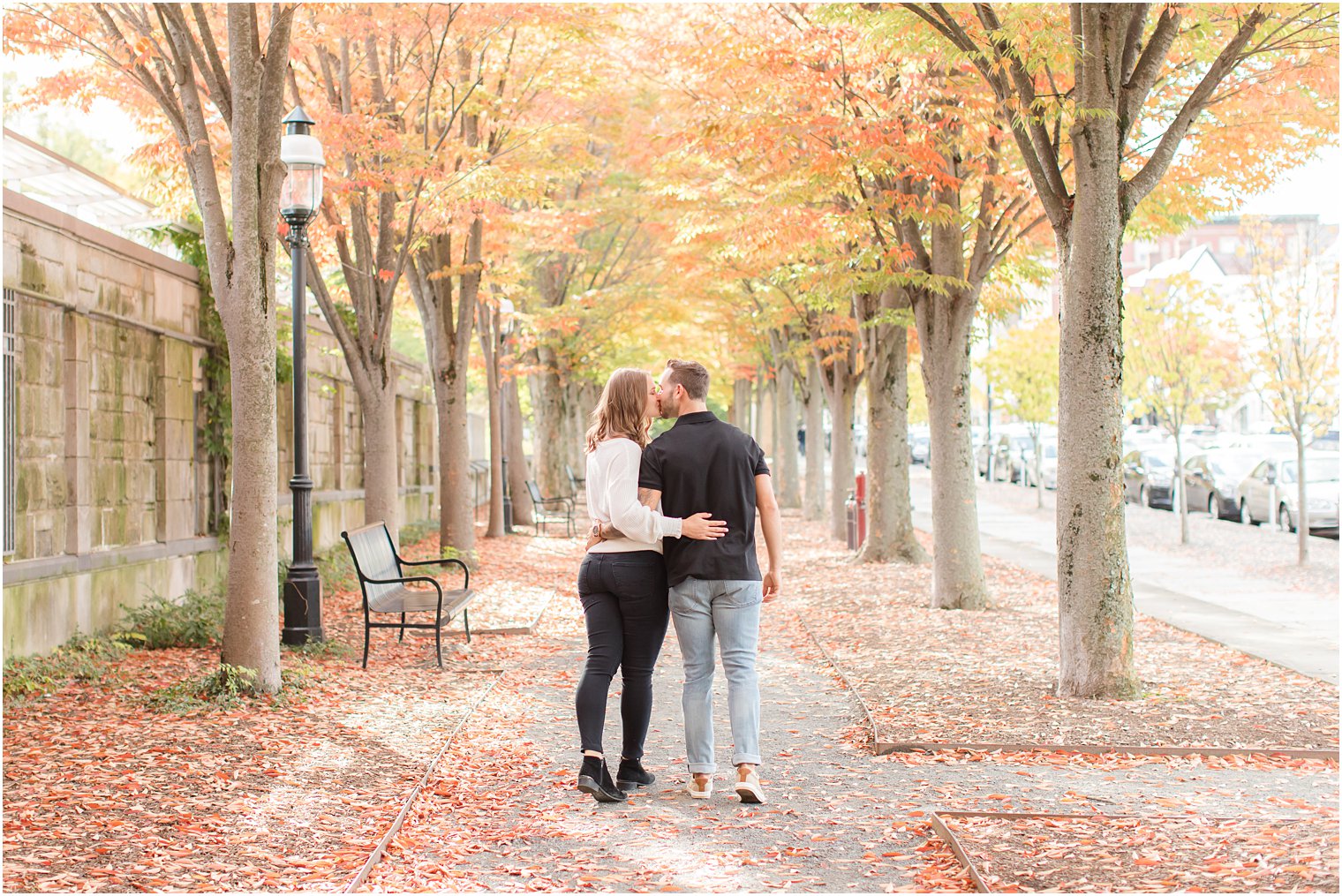 couple kisses on sidewalk near Princeton NJ during fall engagement session 