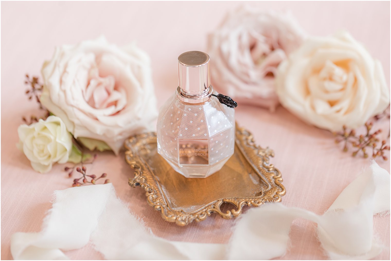 bride's pink perfume bottle rests on gold tray