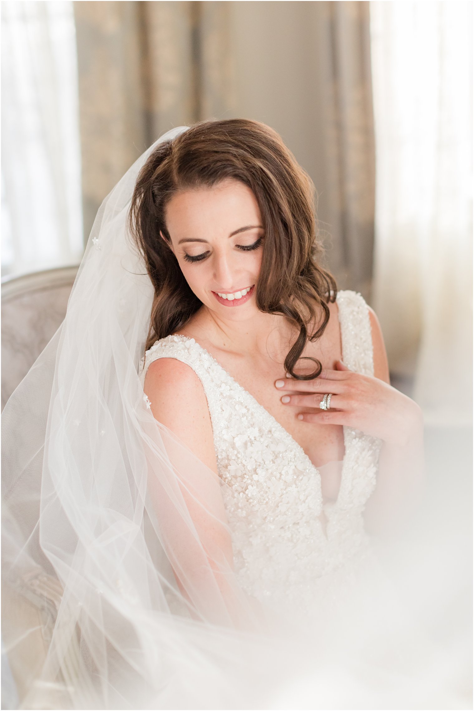 bride sits in chair with veil around her during portraits at Park Chateau Estate 