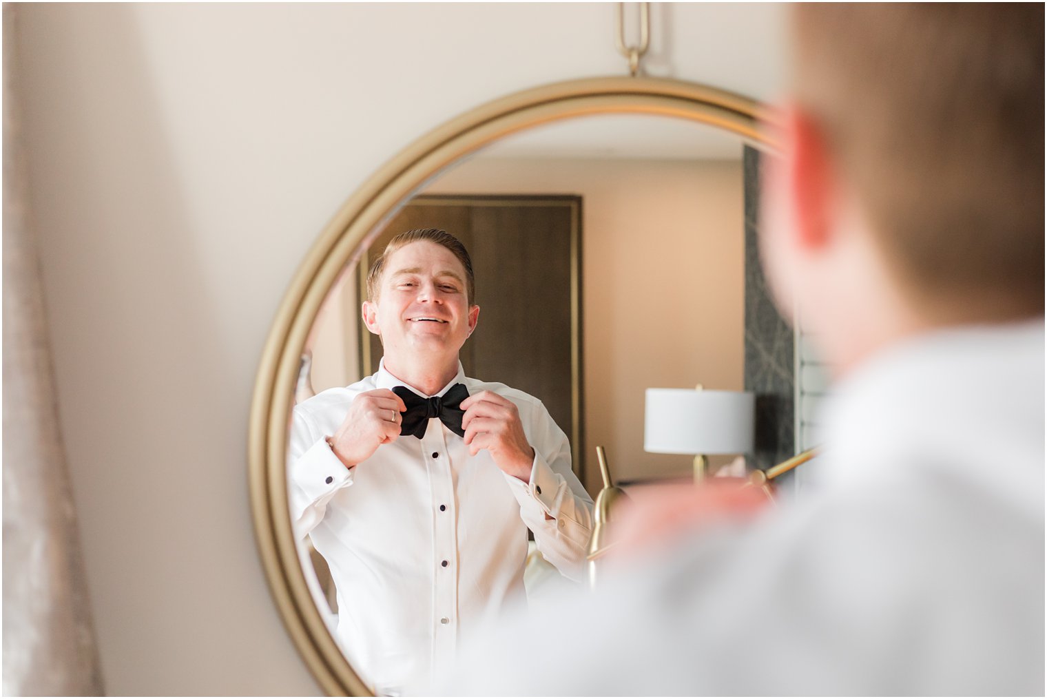 groom adjusts bow tie before NJ wedding day 