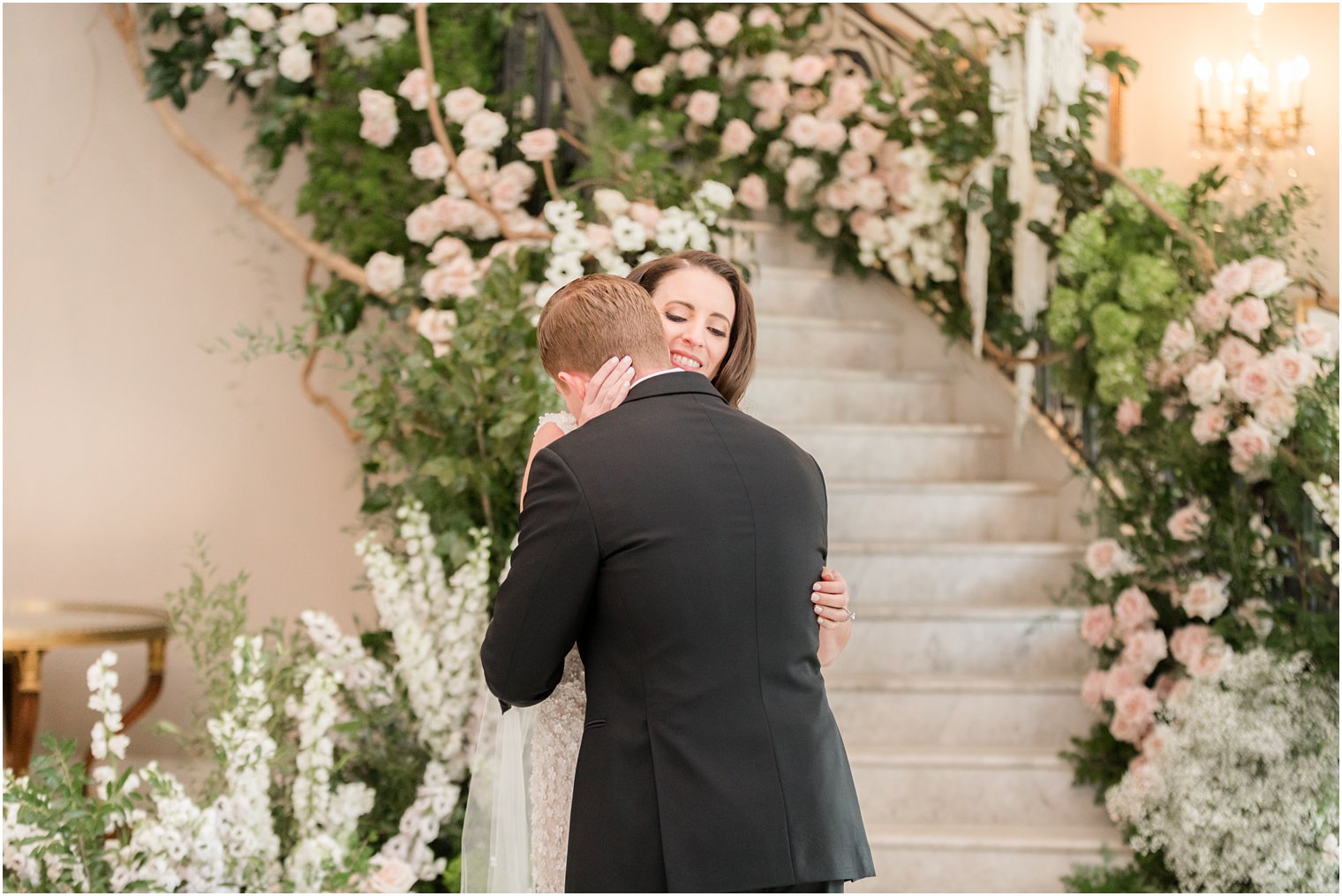 bride and groom hug by staircase at Park Chateau Estate during first look