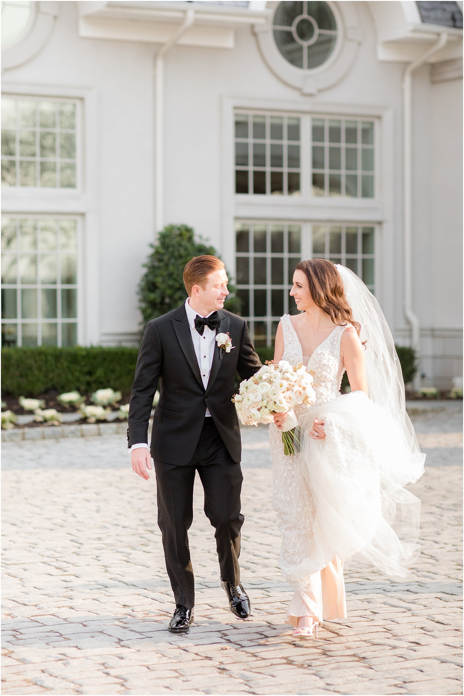 bride and groom hold hands walking around property before Park Chateau winter wedding