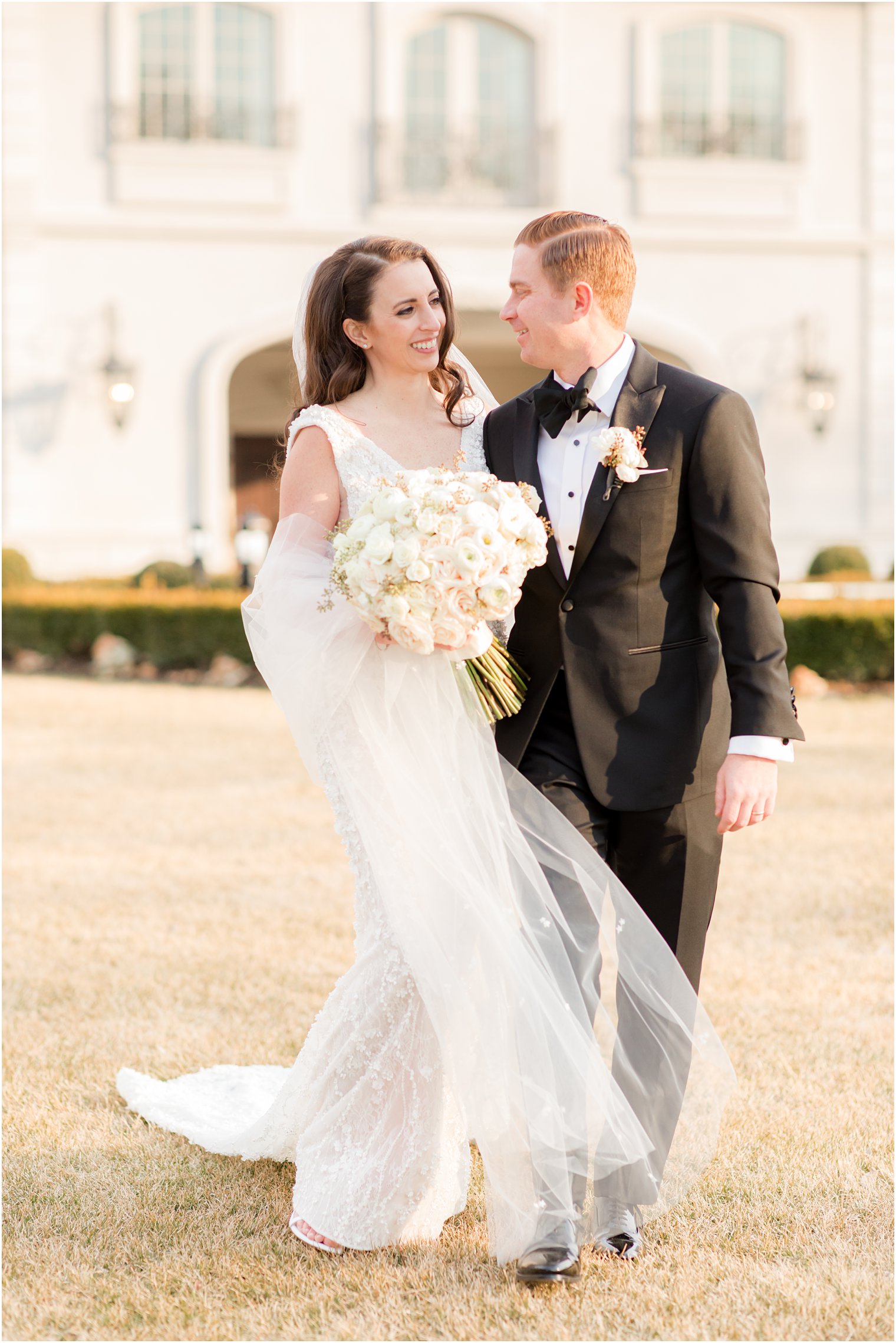 bride and groom hug close walking on lawn in East Brunswick NJ