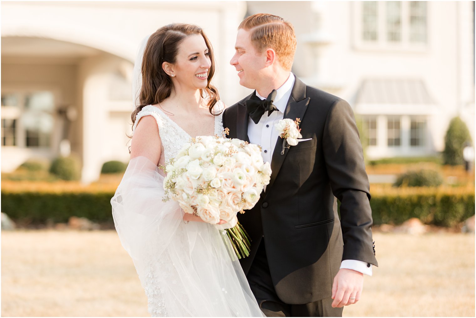 newlyweds smile together laughing on lawn in New Jersey 