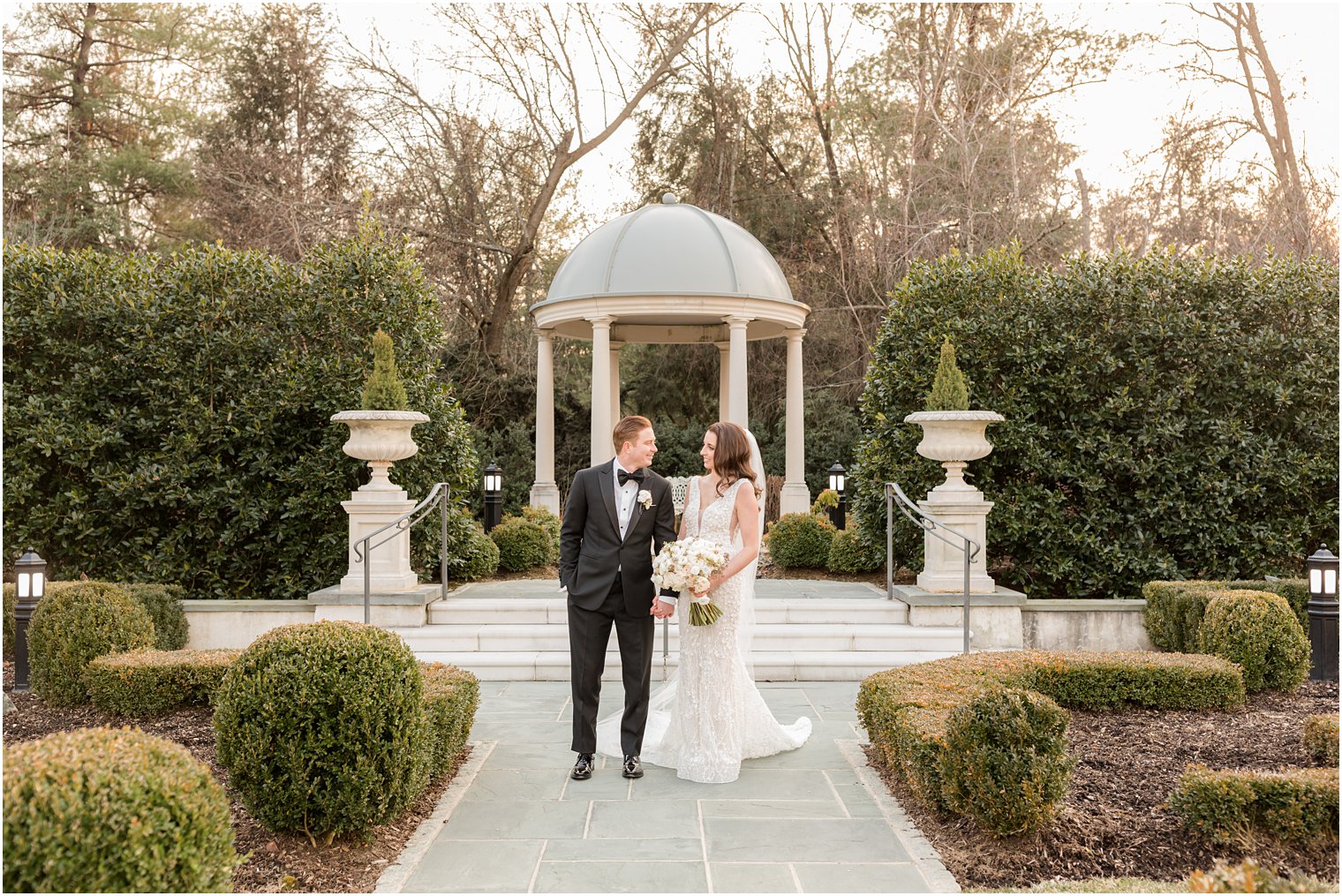 bride and groom walk through gardens at Park Chateau Estate 