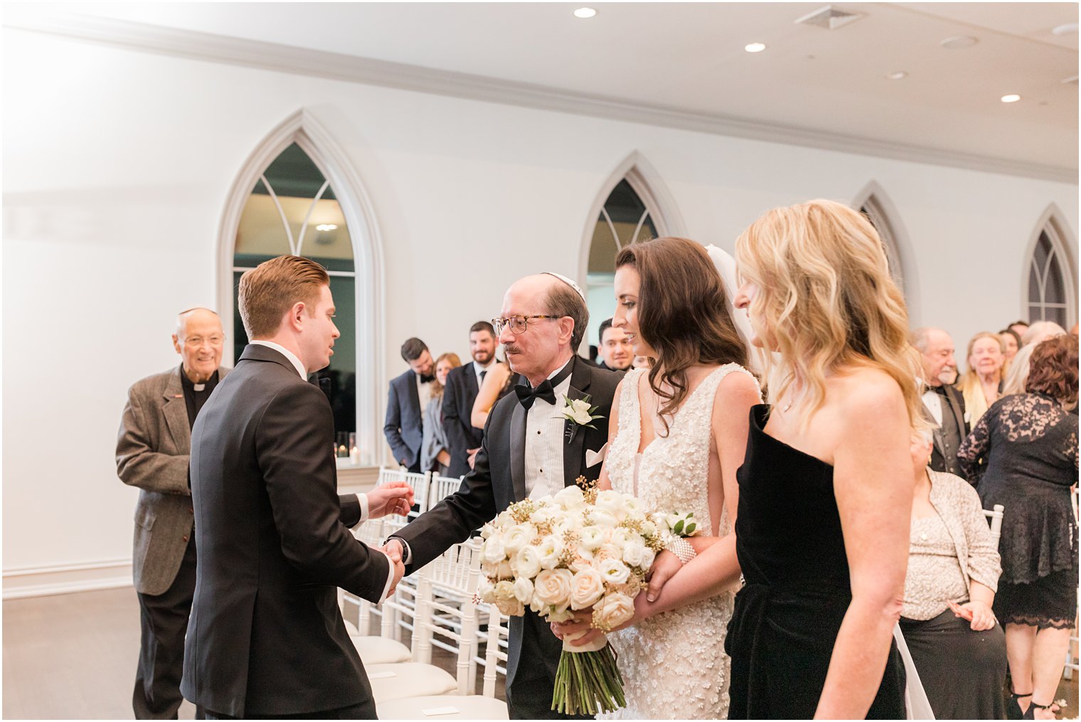 father shakes groom's hand during wedding ceremony 