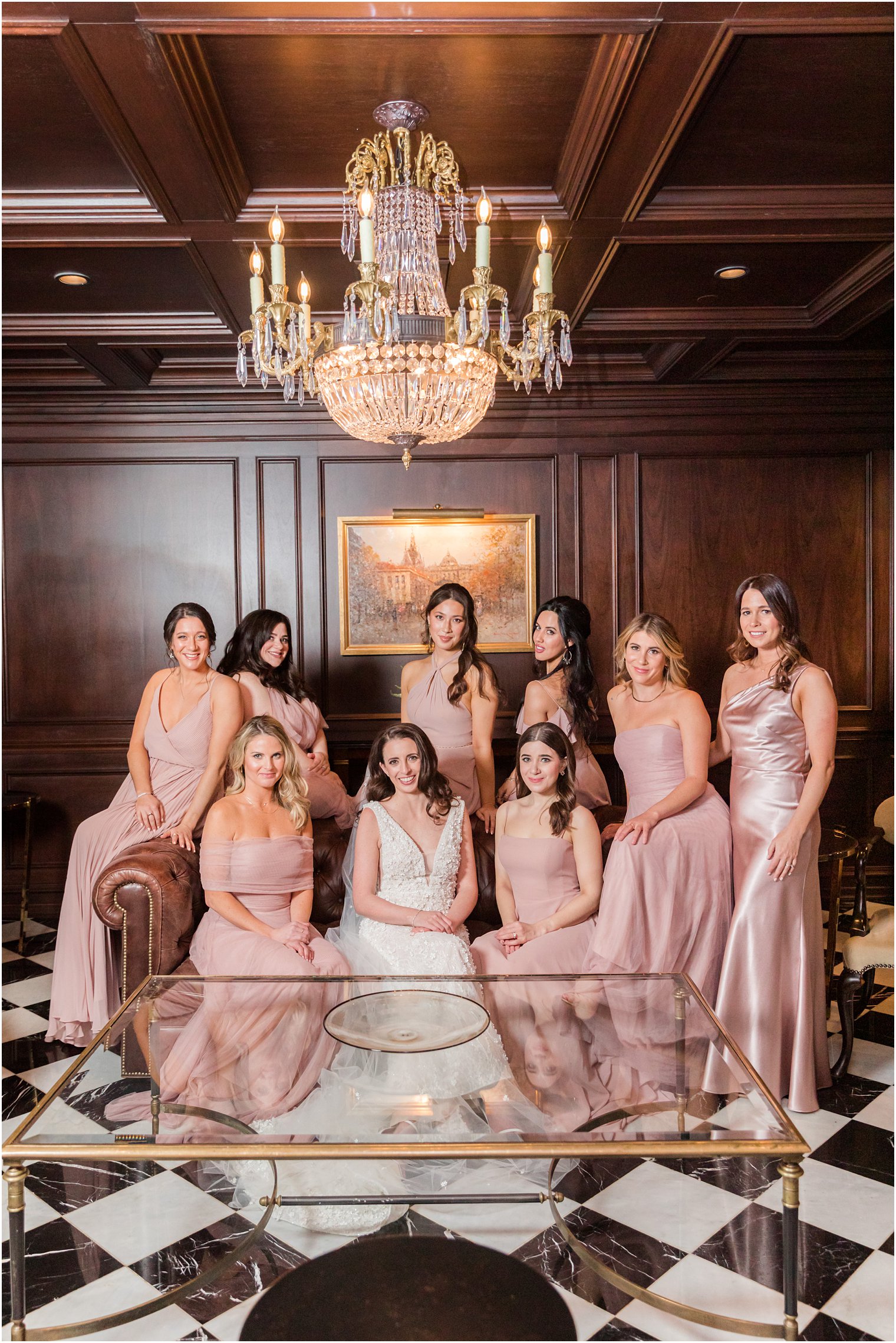 bride poses with bridesmaids on leather couch in studio at Park Chateau 