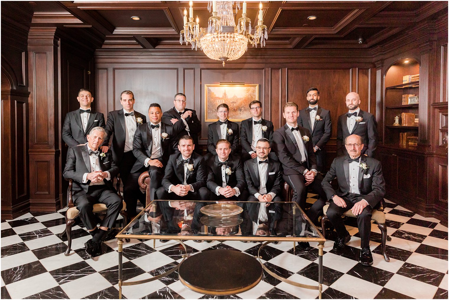 groom sits with groomsmen on leather couch in Park Chateau Estate 