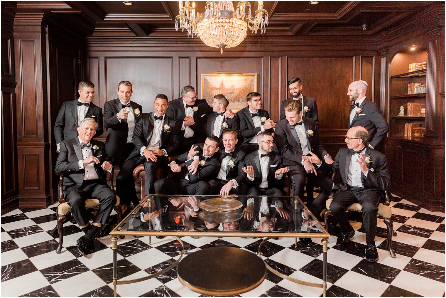 groom and groomsmen laugh and hug together during photos in study at Park Chateau Estate 