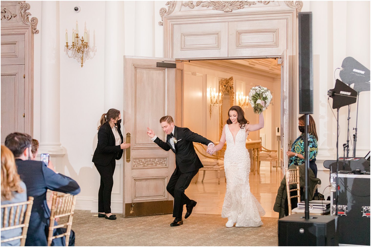 bride and groom cheer walking into East Brunswick NJ wedding reception 