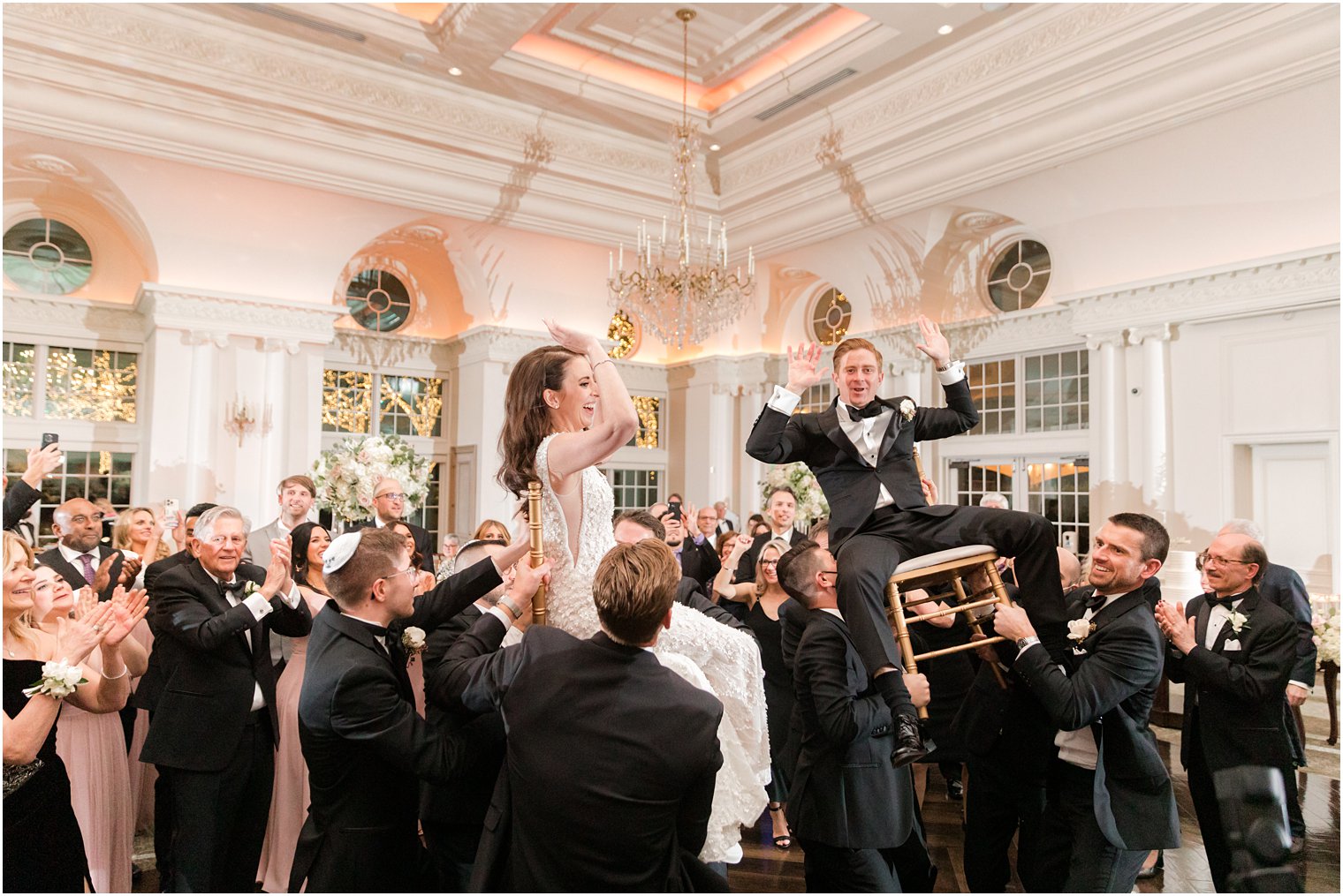 groomsmen lift bride and groom during Hora at East Brunswick NJ wedding reception 