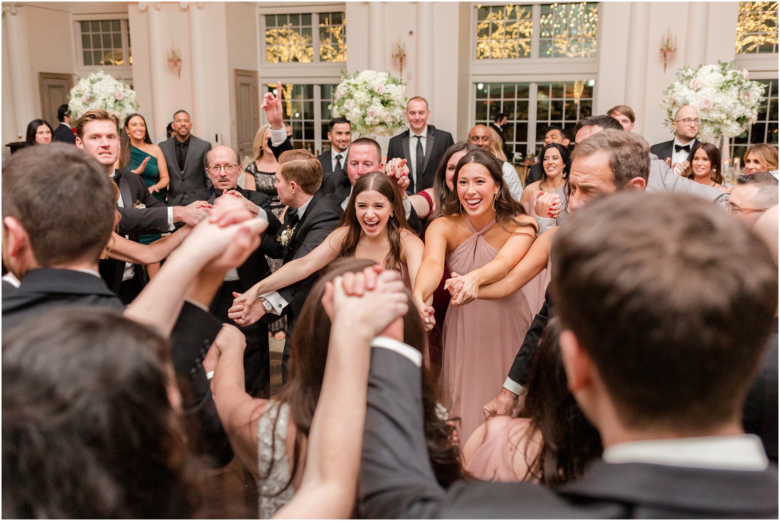 wedding party holds hands during East Brunswick NJ wedding reception 