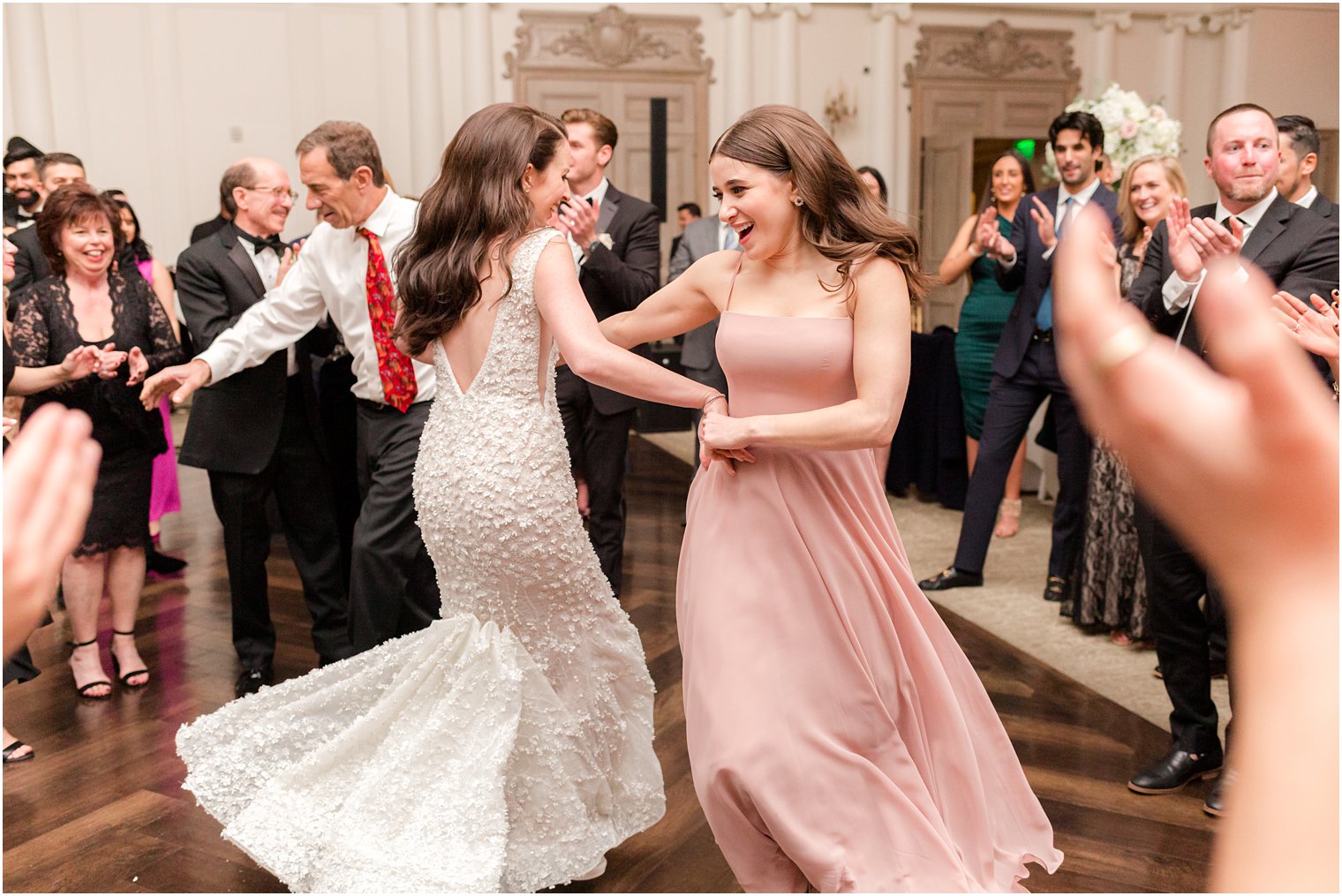 bride and bridesmaid dance together during East Brunswick NJ wedding reception 