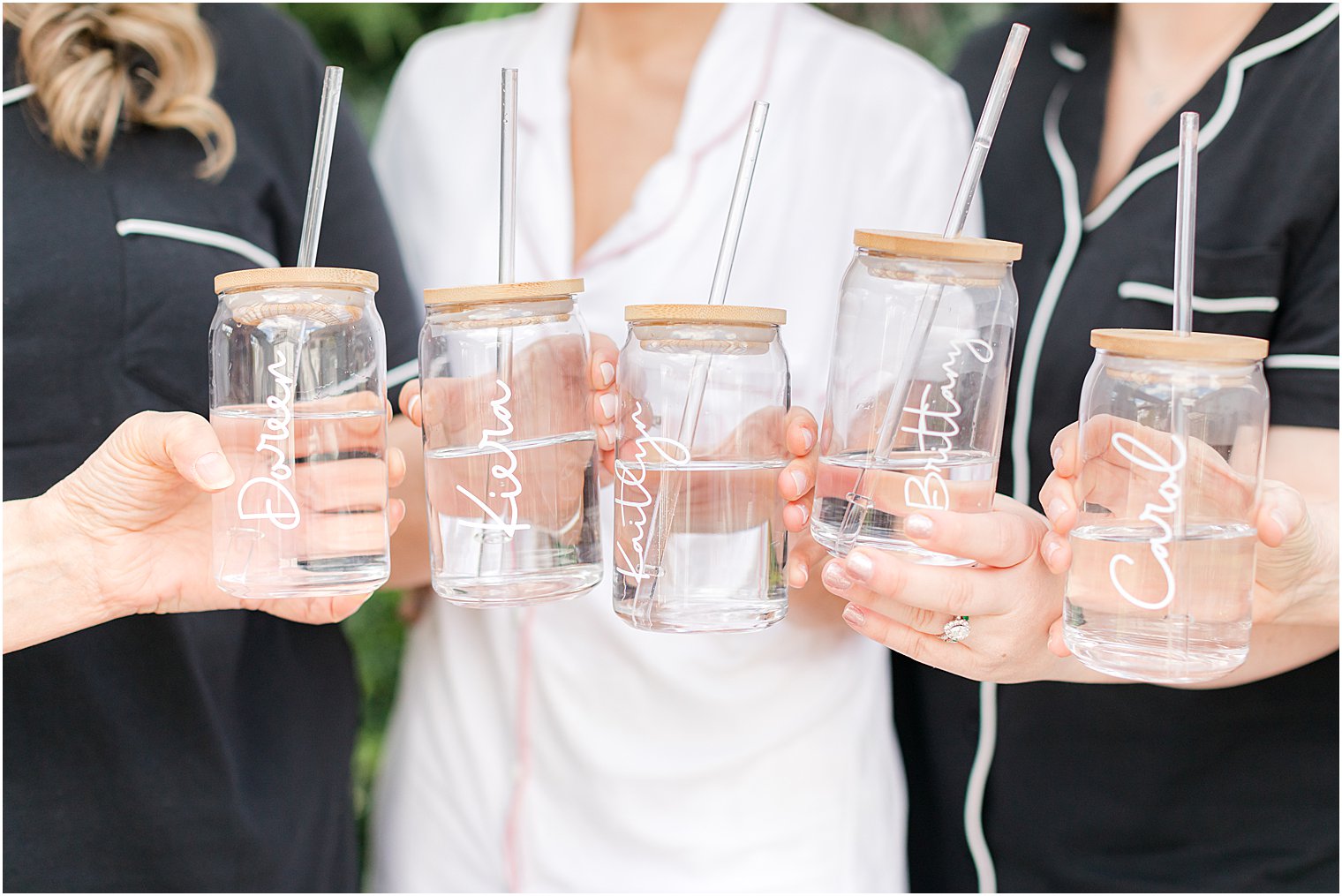 bride and bridesmaids hold mason jars with names