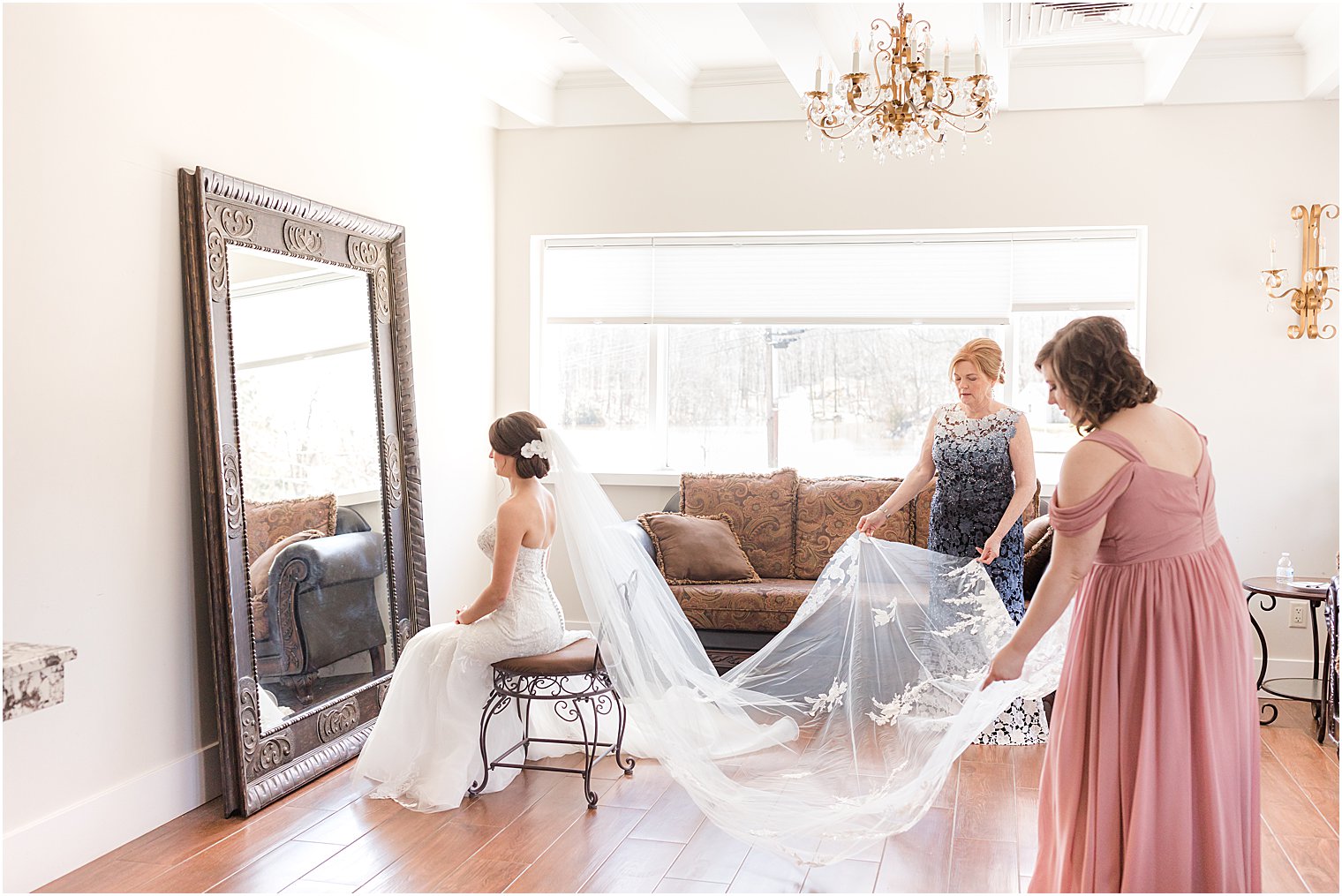 bridesmaid and mom drape veil for bride