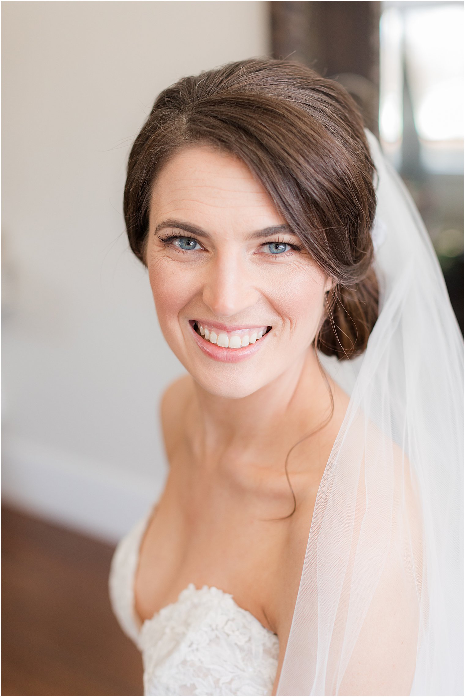 bride sits with veil around shoulders smiling