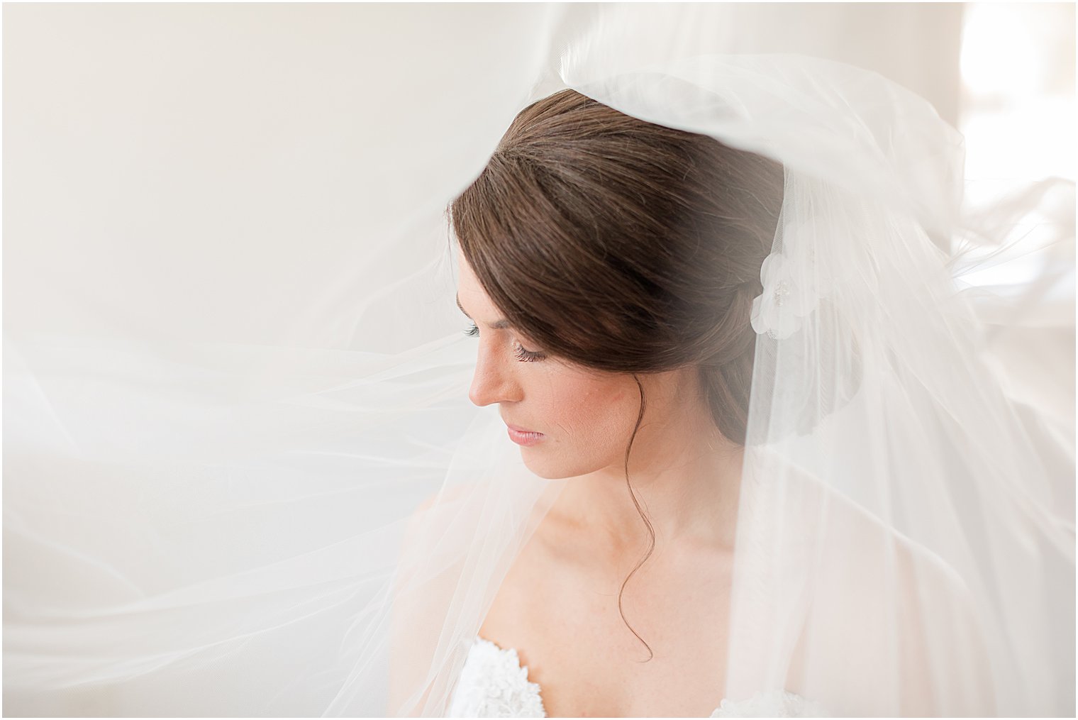 bride looks down with veil over head 