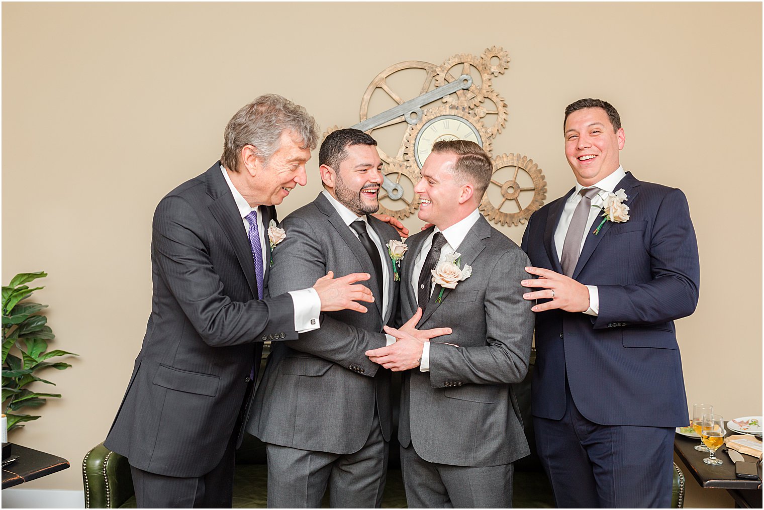 groom, father, and groomsmen pose in grey suits at The Refinery at Perona Farms
