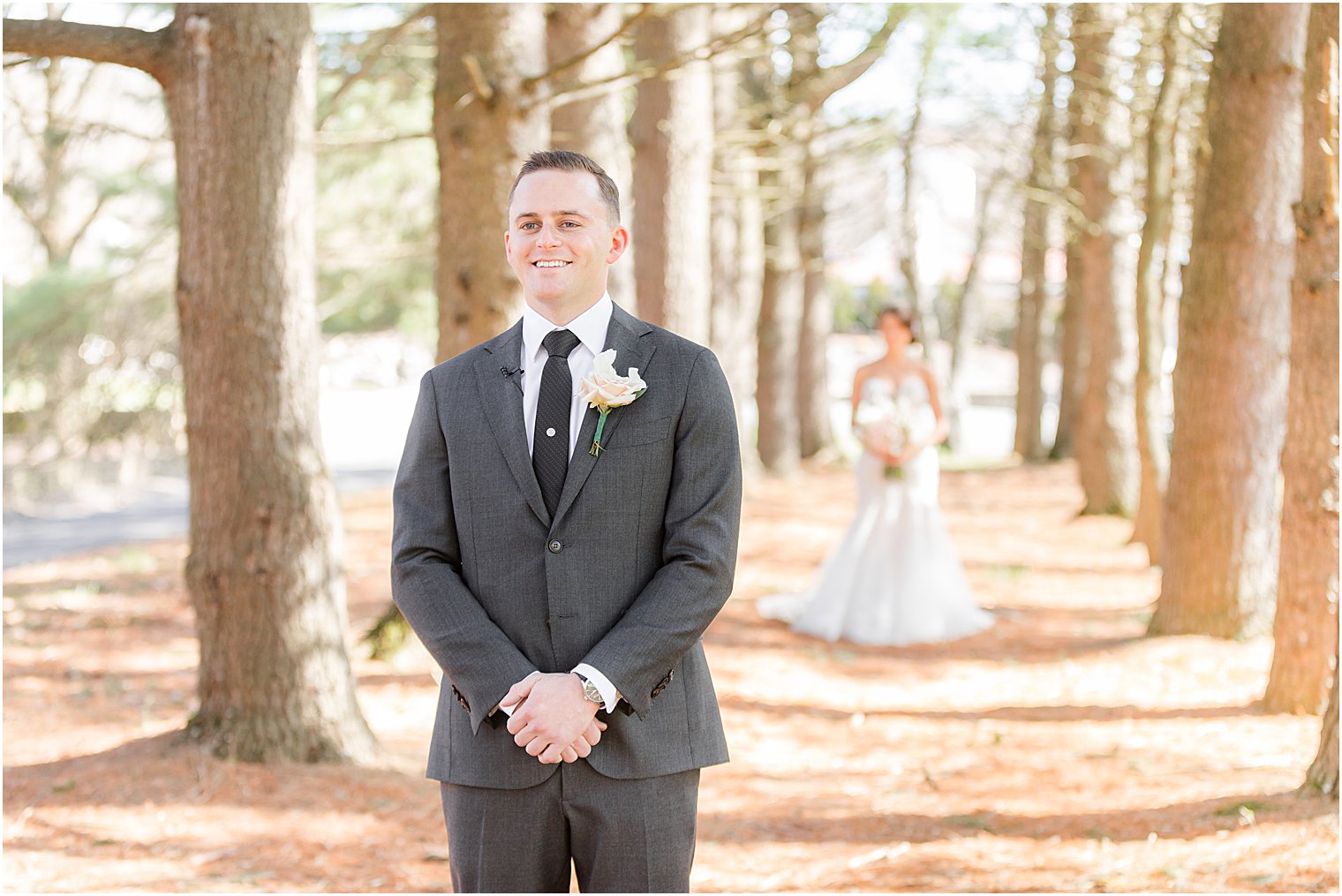 bride walks behind groom during first look