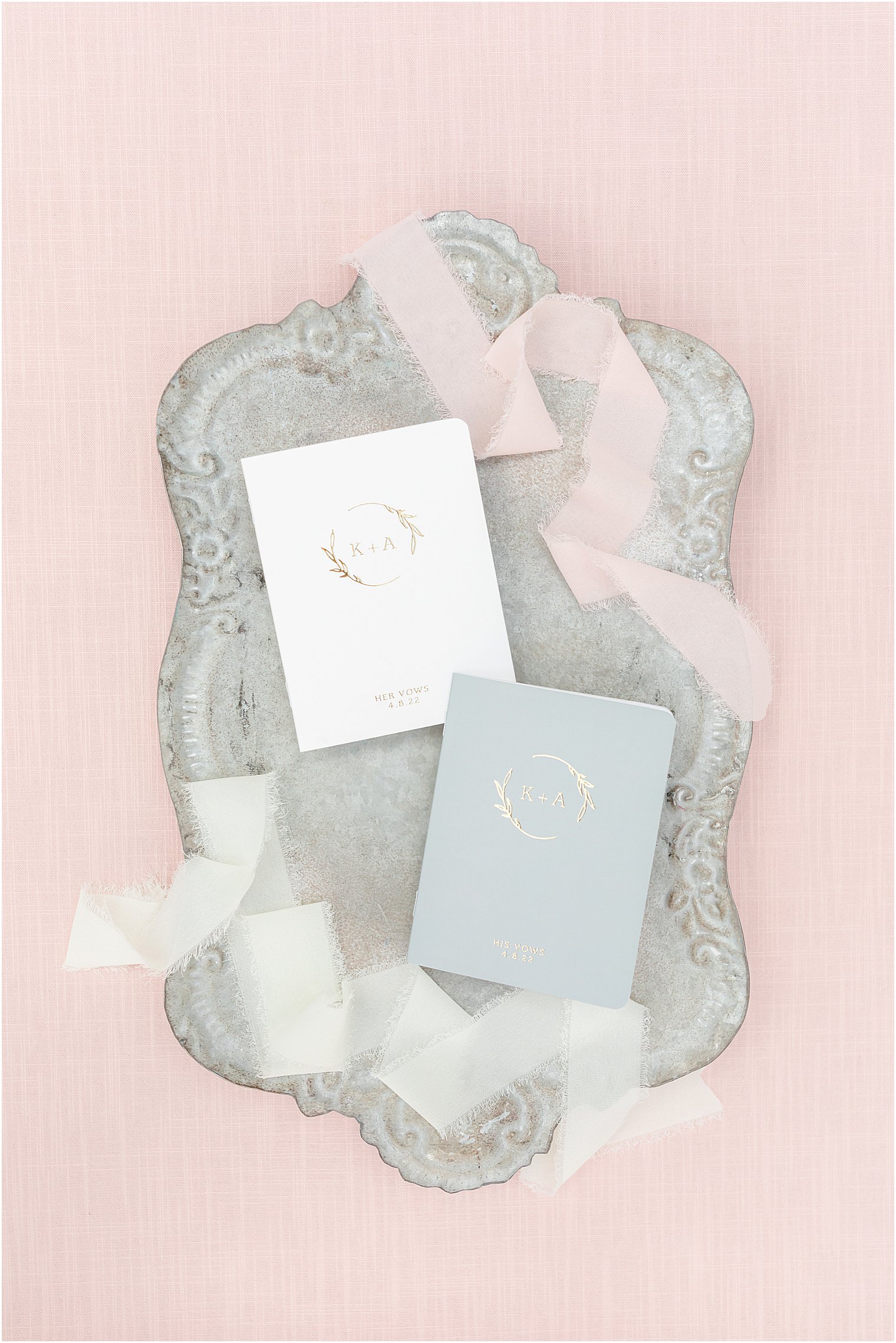 vow booklets rest on silver tray with pink ribbon
