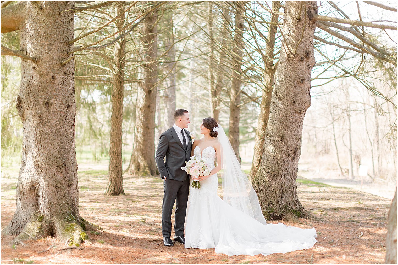 bride and groom smile together in woods at The Refinery at Perona Farms