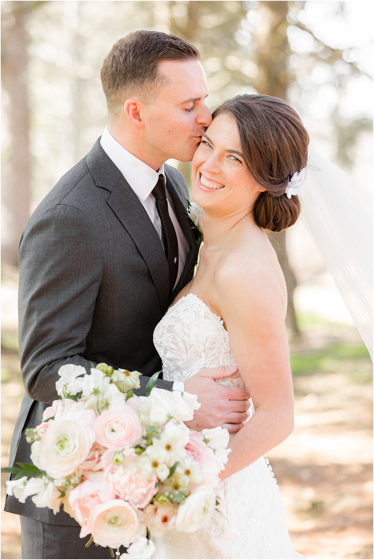 groom kisses bride's cheek during NJ wedding portraits at The Refinery at Perona Farms