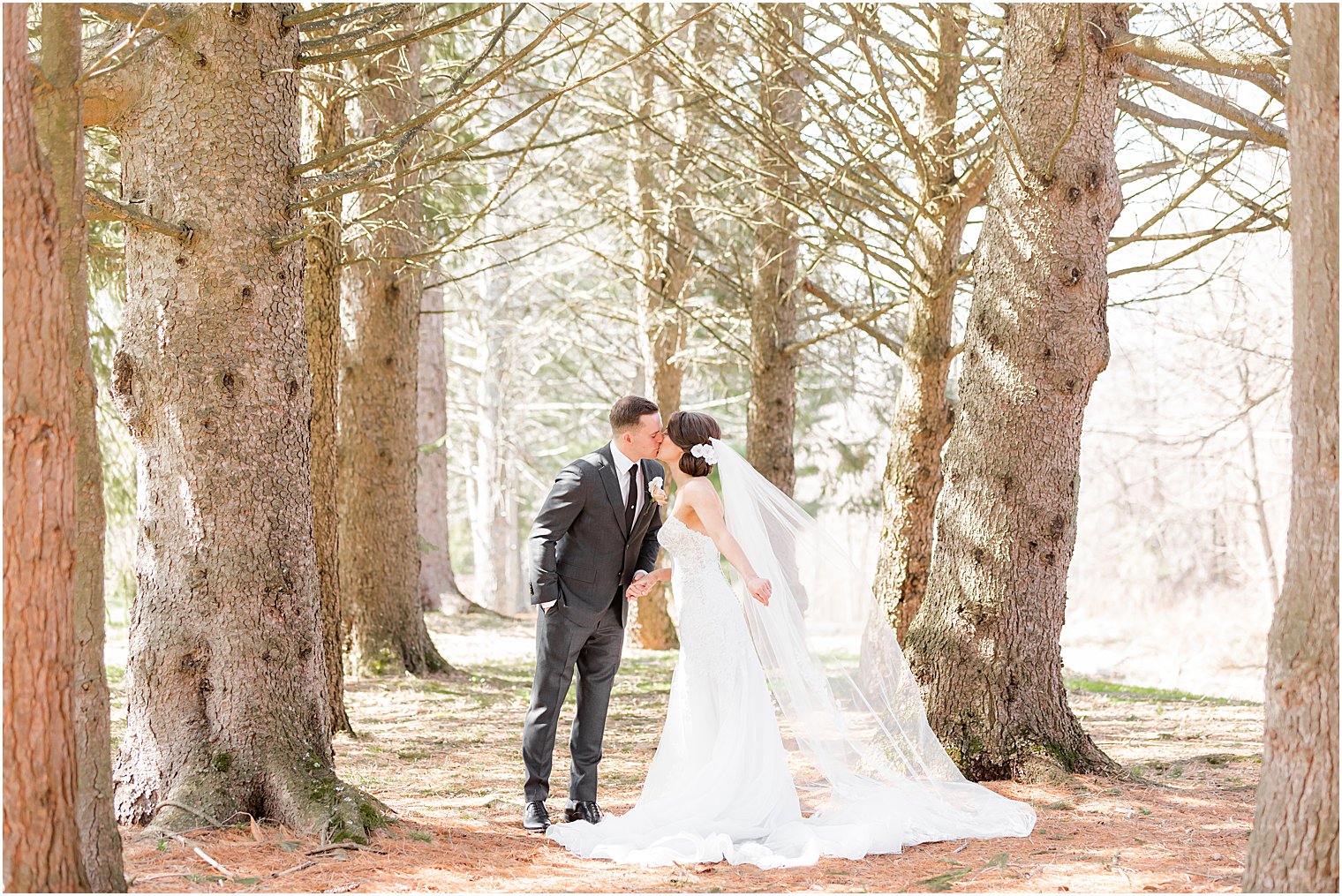 bride and groom kiss together in woods